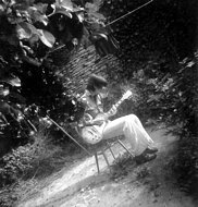 Hugh plays guitar in the small yard that was the back garden.