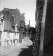 Hugh leans from the other window with the church in the background.